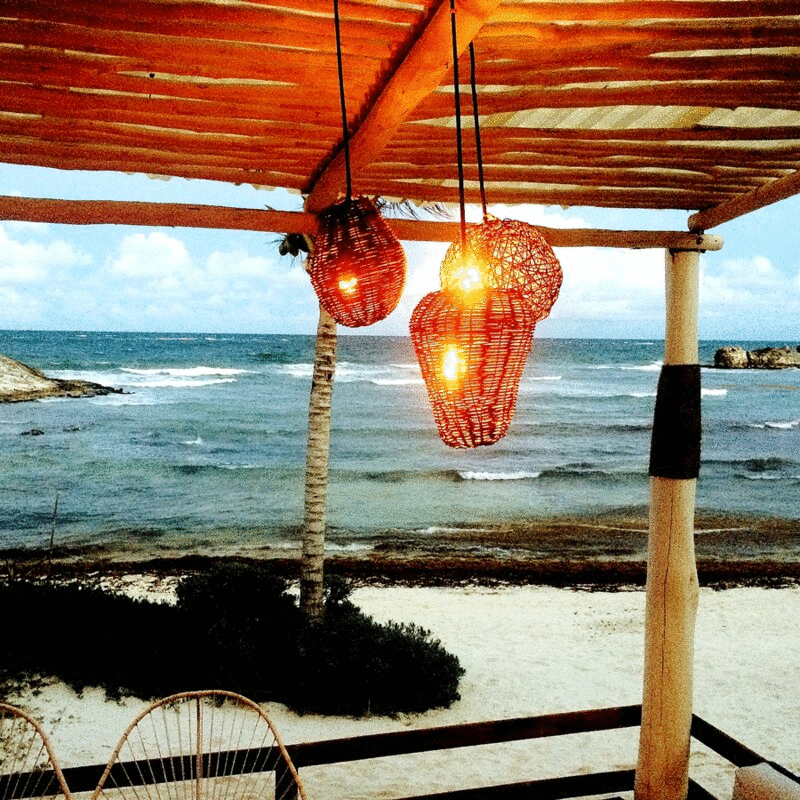 纸灯笼挂在凉棚海滩与翻滚的波浪背景，图伦，墨西哥图片下载