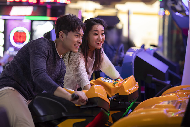 快乐的年轻情侣玩街机游戏图片素材
