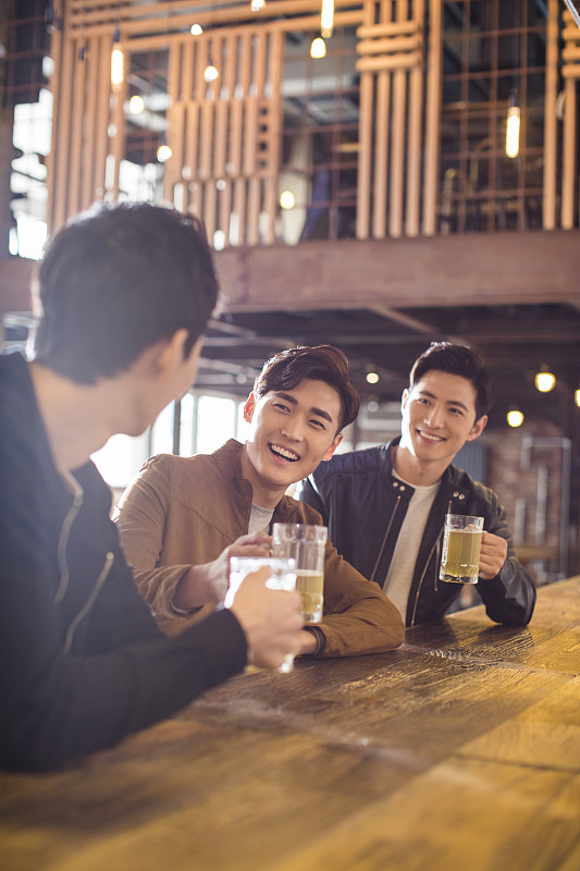 快乐的年轻男士在酒吧喝酒图片下载