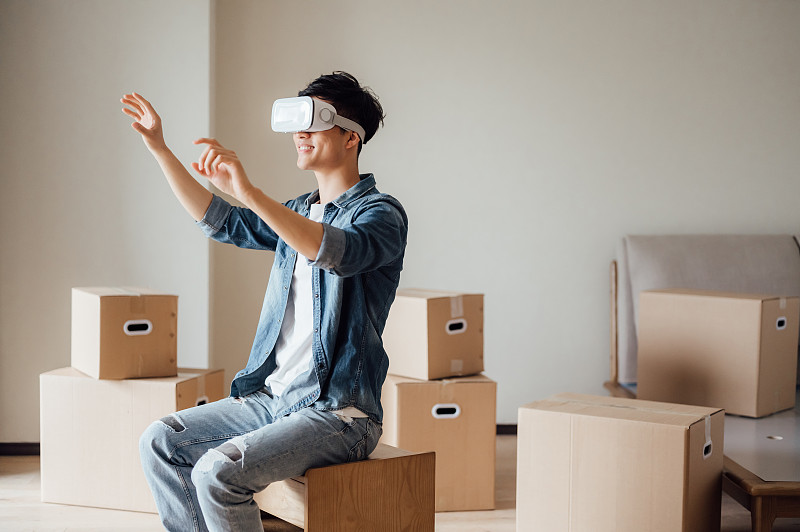 亚洲年轻男孩在新家使用VR眼镜图片下载