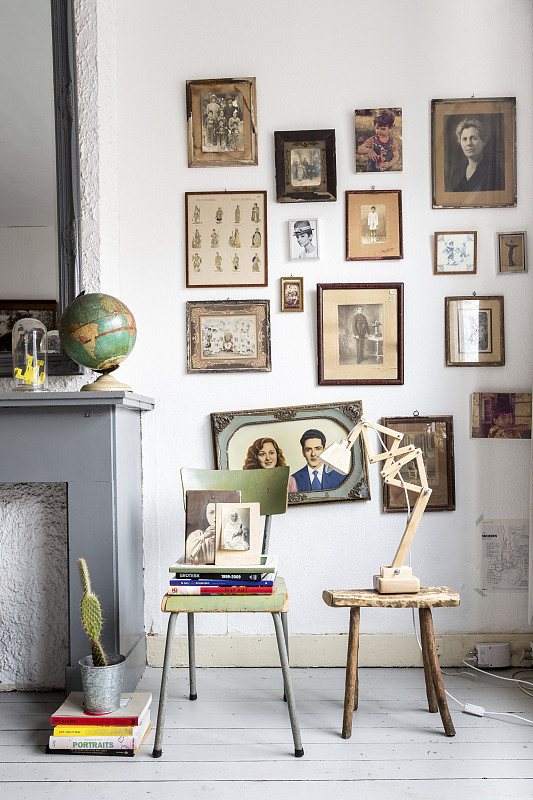 旧椅子和凳子上面的墙上挂着复古的棕褐色照片摄影图片下载