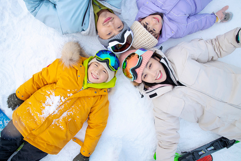 幸福的一家四口躺在雪地上图片素材