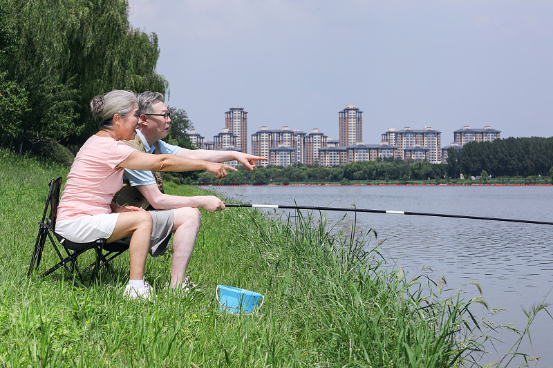 老年夫妇在户外湖边钓鱼图片素材