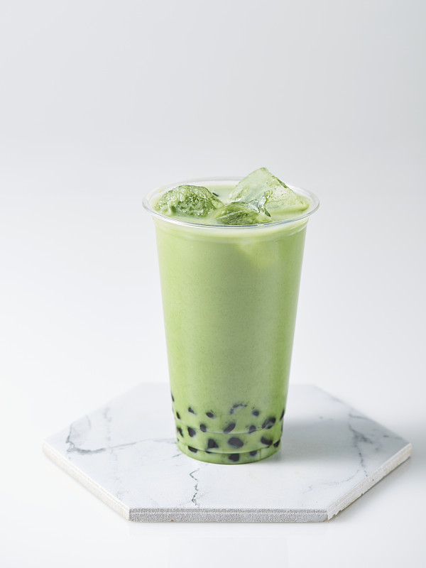 绿茶奶茶与木薯珍珠和冰在白色的背景图片下载