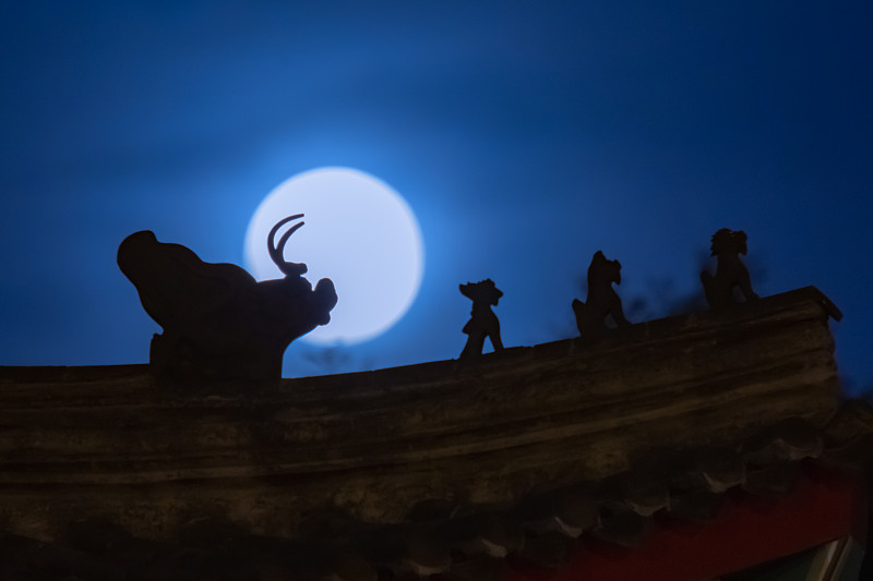 2020年6月5日，北京街头古建筑，满月从屋檐脊兽背后升起。图片素材