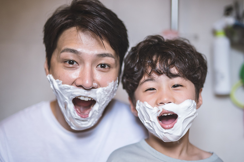 父亲和小儿子脸上涂着剃须膏，脸上露出了表情图片下载