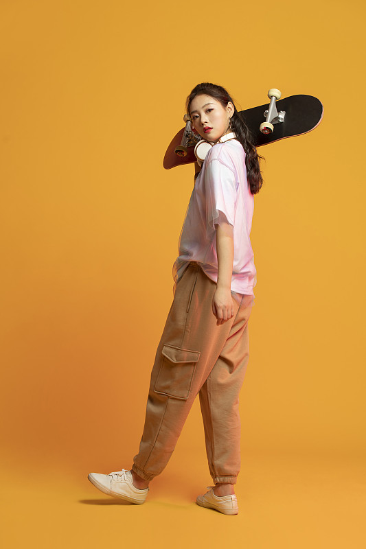 时尚的年轻女孩拿着滑板图片下载