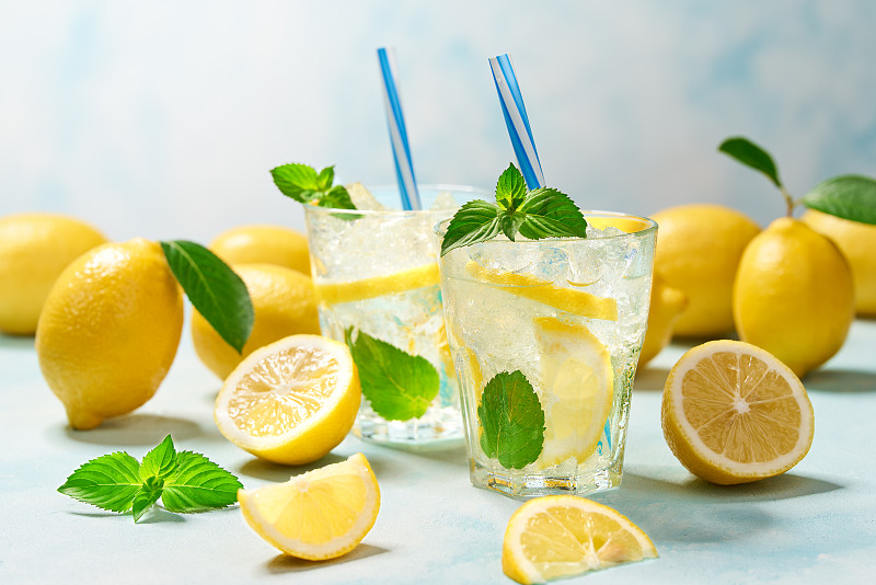 两杯柠檬水，新鲜柠檬，蓝绿色背景图片下载