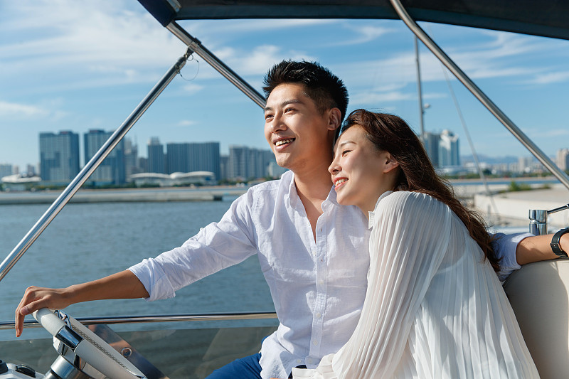 浪漫的青年夫妇驾驶游艇出海图片素材