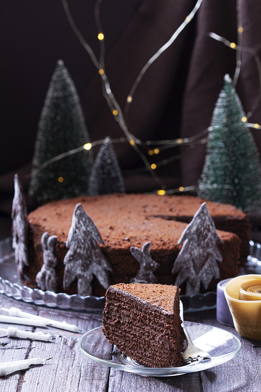 木制背景的巧克力蜂蜜蛋糕作为圣诞装饰图片下载