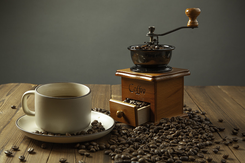 木头桌子上的咖啡豆，研磨机，咖啡杯图片下载
