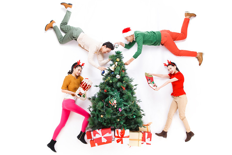 四个青年男女正在装饰圣诞树图片下载