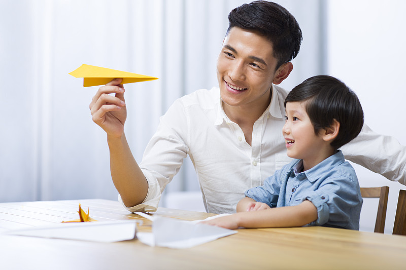 父亲和儿子一起折纸飞机图片下载