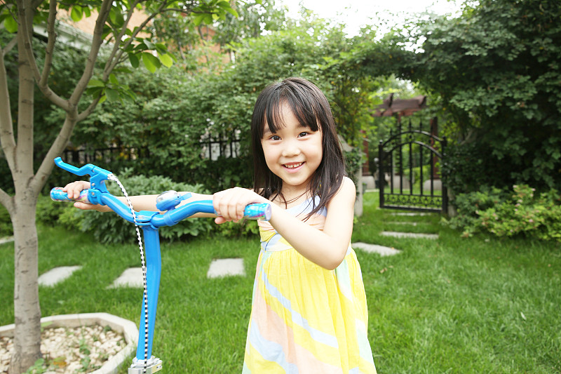 快乐的小女孩骑滑板车图片素材