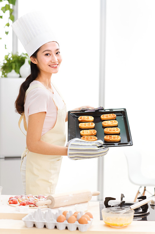 年轻女人在厨房烤面包图片下载
