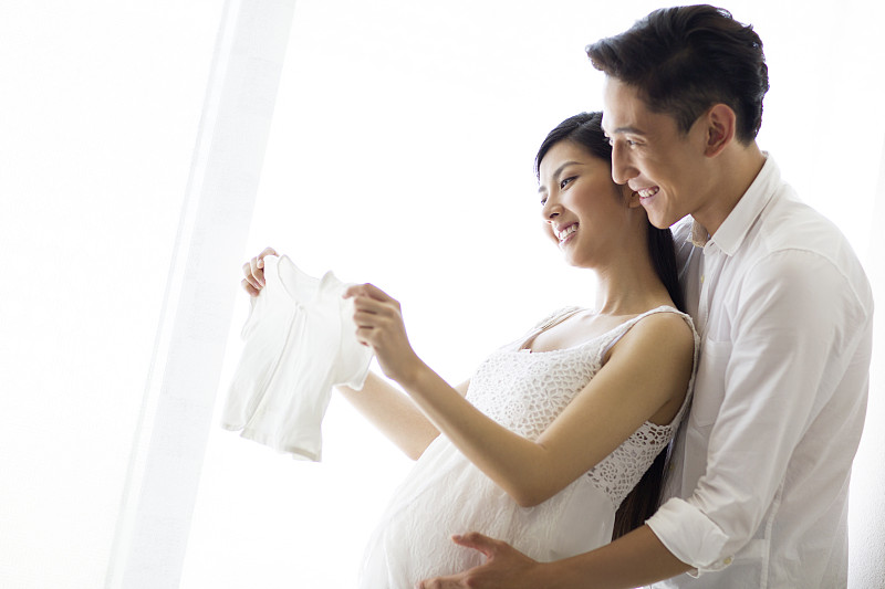年轻夫妇和婴儿衣服图片下载
