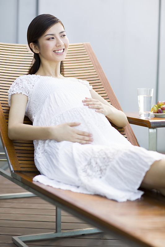 孕妇靠在躺椅上休息图片下载