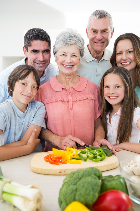 微笑的一家几代在厨房柜台准备食物的肖像图片下载