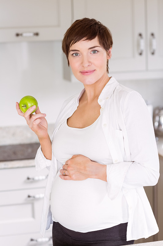 孕妇在家厨房吃苹果图片素材