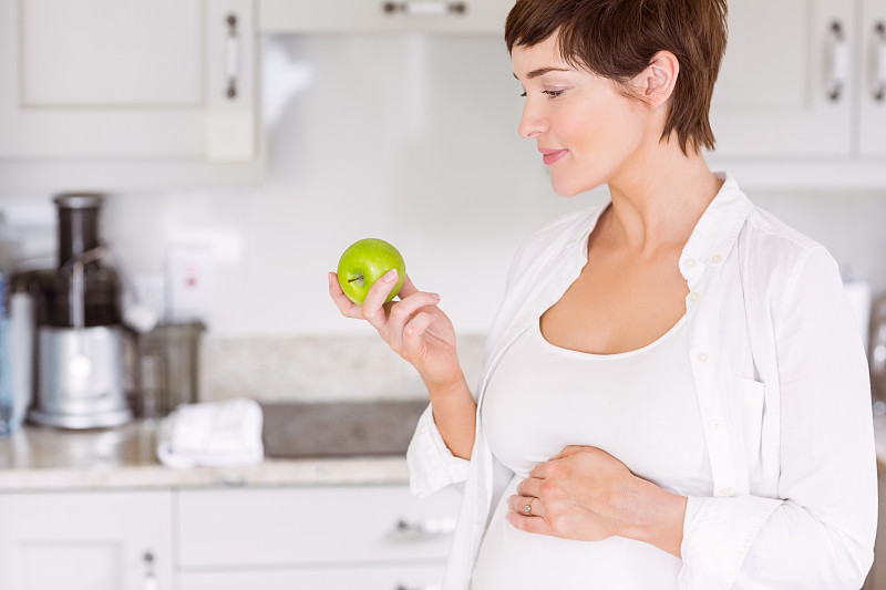 孕妇在家厨房吃苹果图片下载