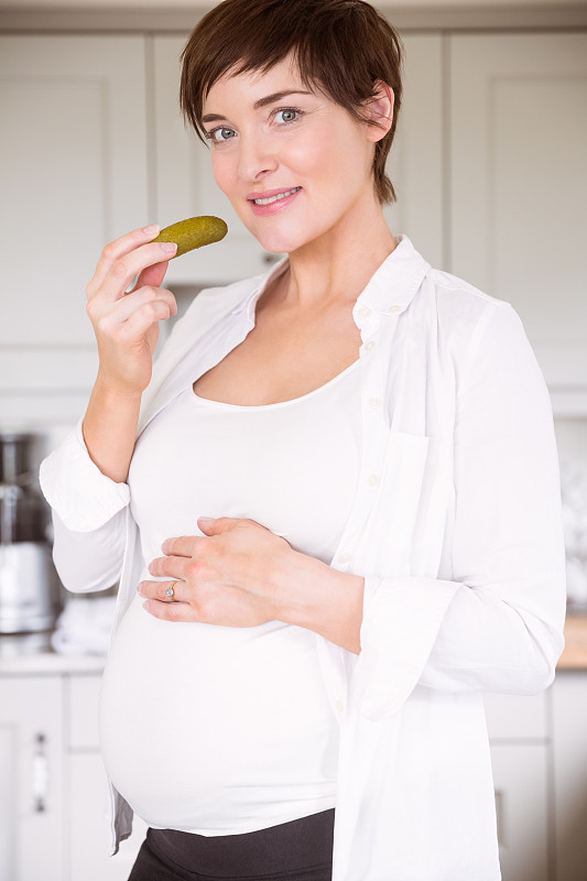 孕妇在家厨房吃泡菜罐图片素材