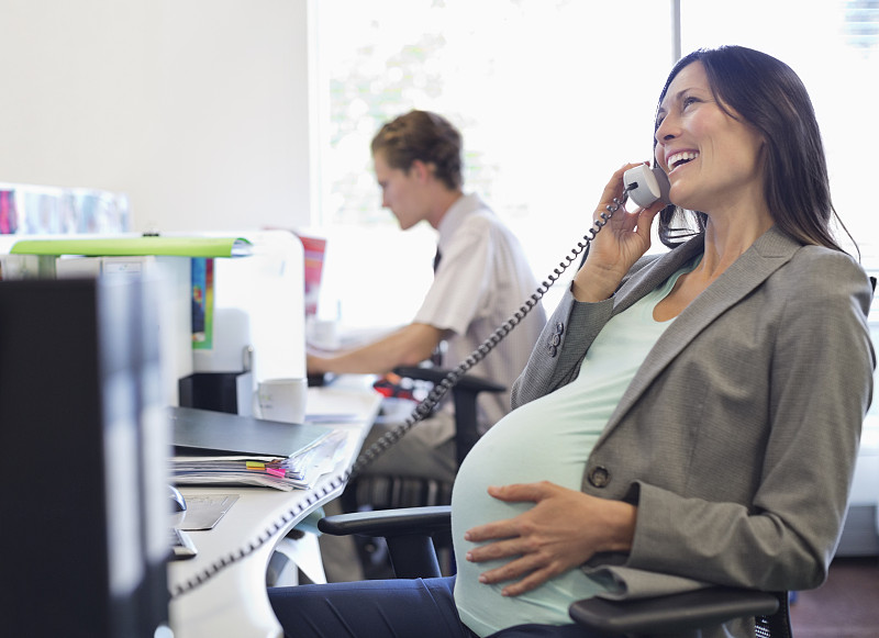 怀孕的女商人在打电话图片素材