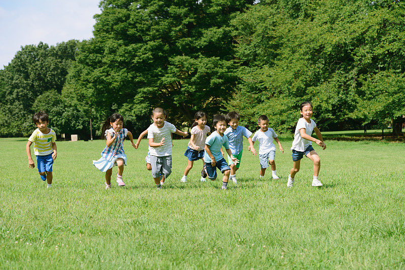 日本孩子在城市公园里跑步图片下载