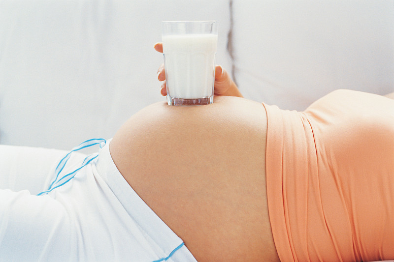 孕妇肚子上的一杯牛奶图片下载