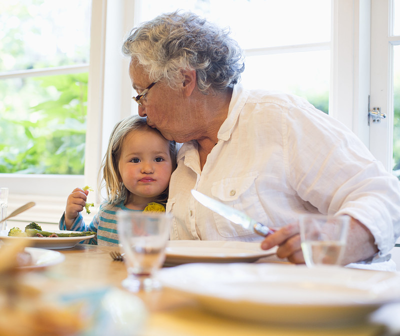 美国加州，小女孩(2-3)和奶奶一起吃晚餐，得到亲吻图片下载