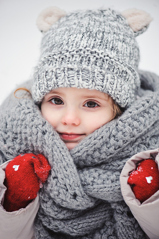 快乐的小女孩在雪地里散步图片下载