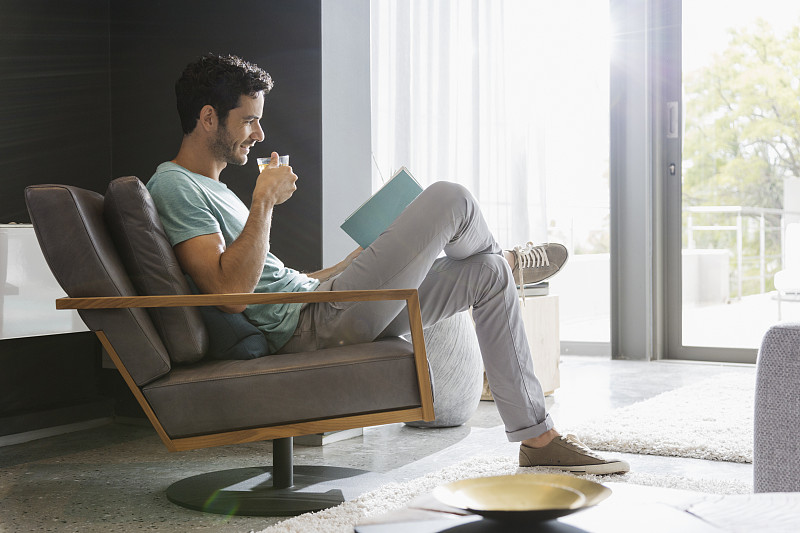 男人在客厅喝茶看书图片素材