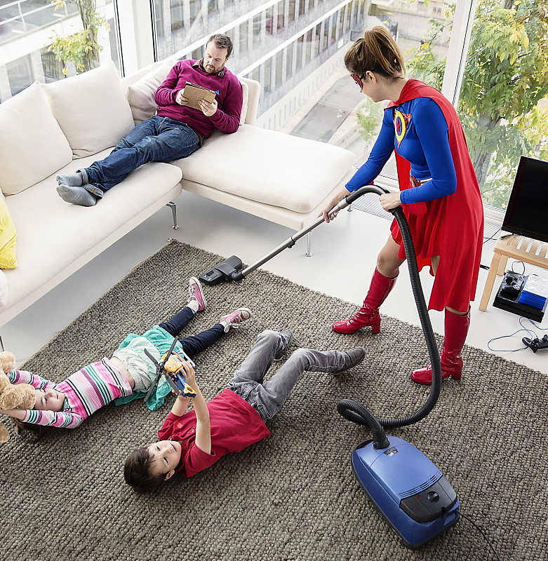 超级英雄在客厅和家人一起吸尘图片下载
