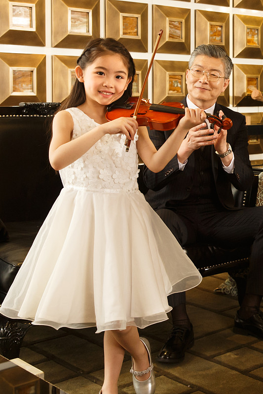 祖父欣赏孙女拉小提琴图片下载
