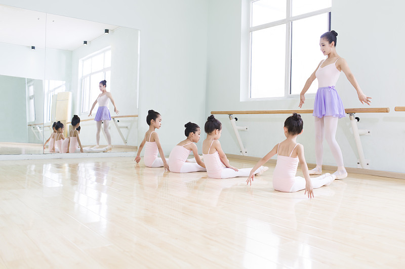年轻舞蹈老师教小女孩们跳芭蕾图片素材