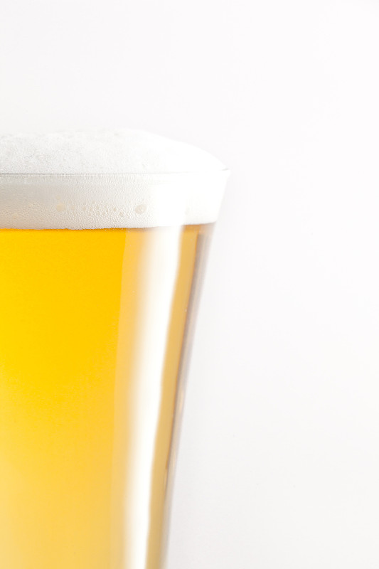在白色的背景下，装满啤酒和泡沫的玻璃杯图片下载