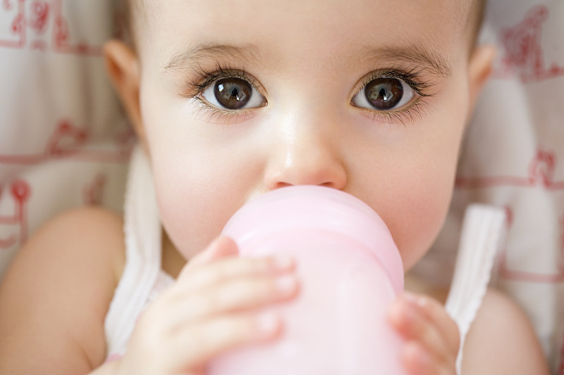 小女孩用奶瓶喝水图片下载