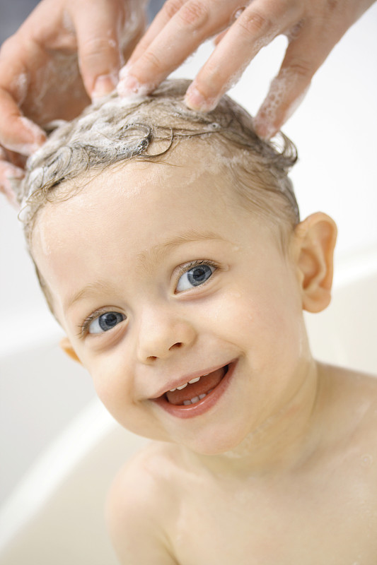 父母在浴缸里给小男孩洗头图片下载