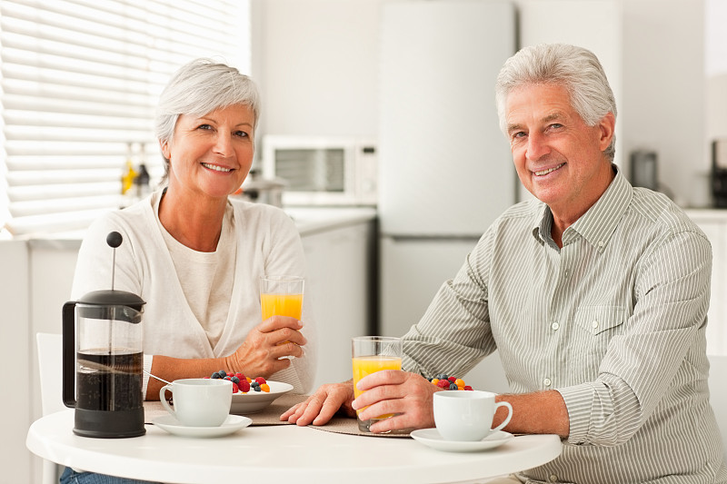 微笑的老年夫妇在家里吃早餐图片素材