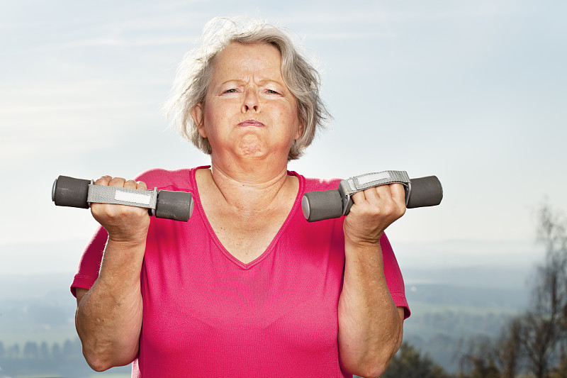 超重的老年妇女努力锻炼图片下载