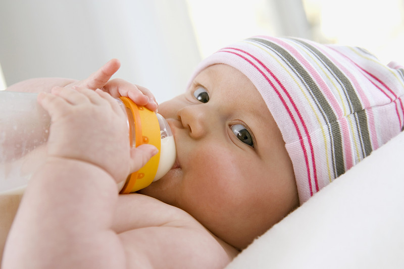 婴儿(6-9个月)从奶瓶里喝牛奶，肖像图片下载