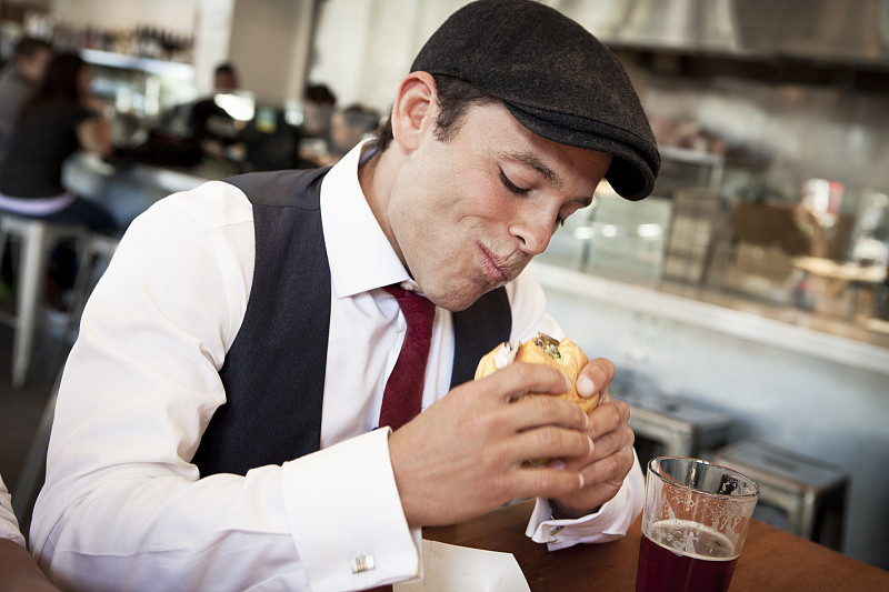 一个人在城里的餐厅吃三明治图片素材