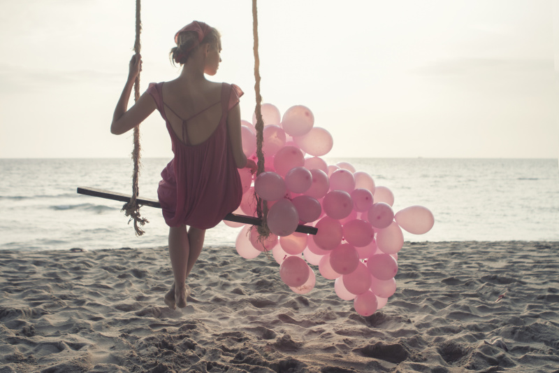 漂亮的女人挥舞着粉红色的气球图片素材