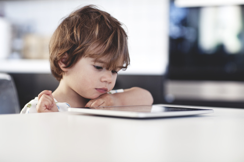 一个小男孩看平板电脑的肖像图片素材