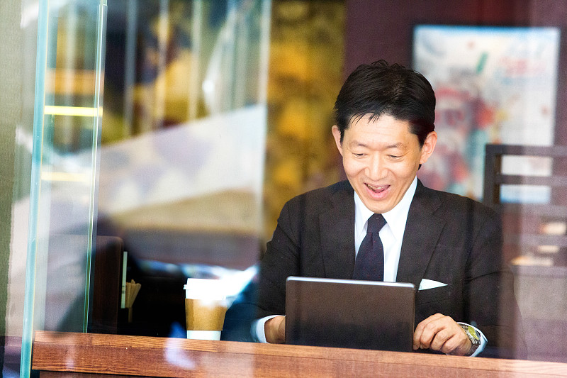 快乐的日本商人在咖啡馆用平板电脑阅读好消息图片下载