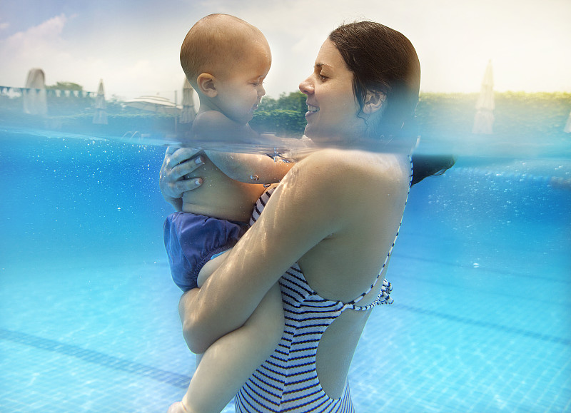 母亲和男婴在游泳池里图片素材