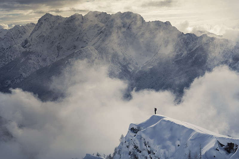 孤独的攀登者站在雪峰上图片下载
