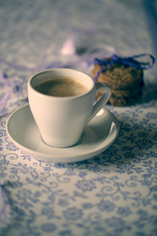 一杯咖啡和图案布上的巧克力饼干图片素材
