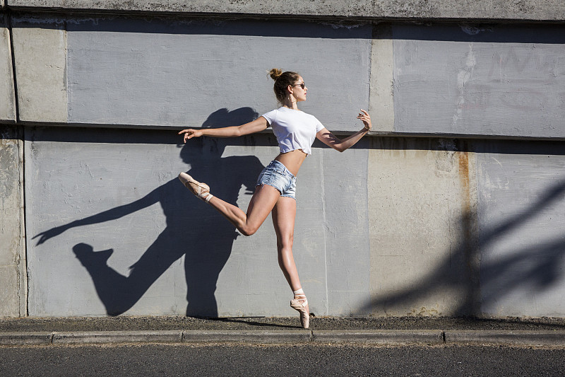 芭蕾舞女演员在人行道上跳跃图片下载