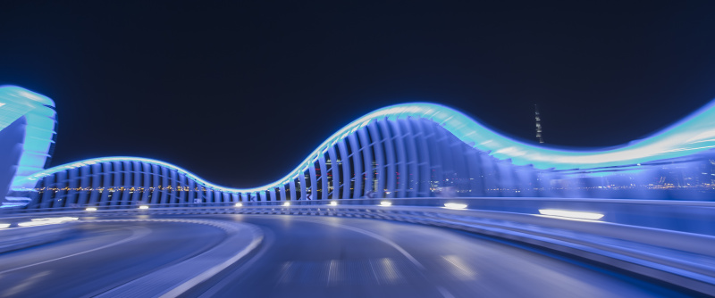 一辆车开在灯光照亮的蓝色桥上图片素材