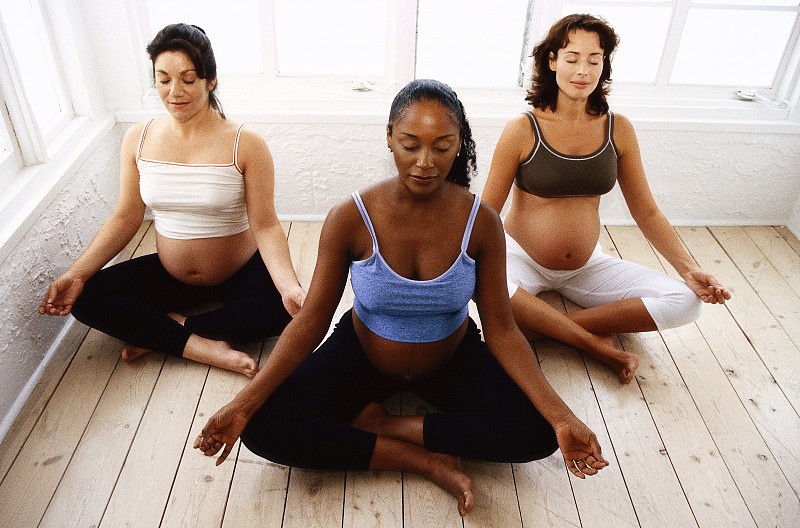 高角度的三个孕妇坐在一个沉思的姿势图片下载
